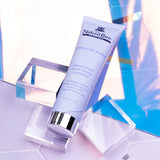 Naked Bee skincare product on a reflective surface with abstract design