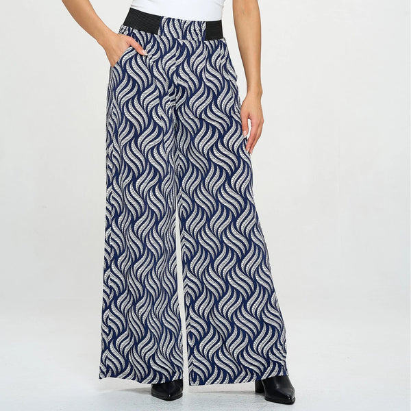 Navy and white patterned wide-leg pants worn by a person on a white background