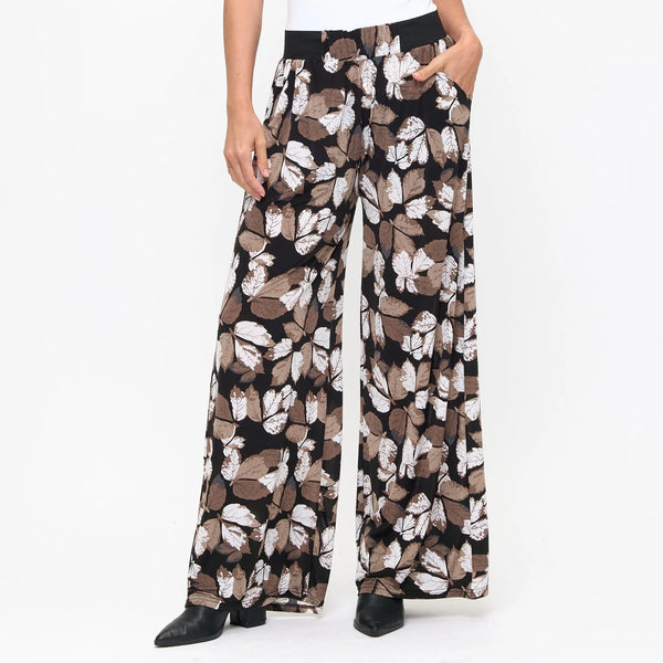Floral patterned pants worn by a person on a white background