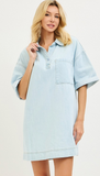 Woman wearing a light blue denim dress against a white background