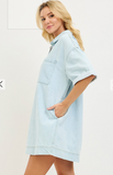 Woman wearing a light blue denim dress on a white background