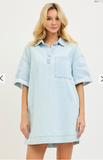Woman wearing a light blue denim dress against a plain background
