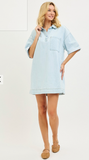 Woman wearing a light blue denim dress on a white background
