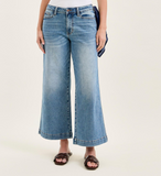 Person wearing blue wide-leg jeans on a white background
