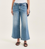 Person wearing light blue wide-leg jeans on a white background