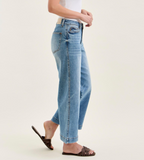 Person wearing light blue jeans on a plain background