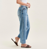 Person wearing light blue jeans on a plain background