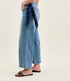 Person wearing light blue jeans with a patterned bandana around the waist on a white background