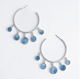 Silver hoop earrings with blue circular charms on a white background
