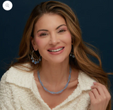 Woman wearing a necklace with a dark blue background