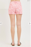 Pink floral shorts worn by a person on a white background