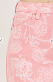 Pink pants with white floral pattern on a light gray background