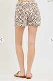 Leopard print shorts worn by a person on a plain background