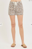 Leopard print shorts worn by a person on a plain background