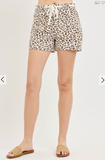 Leopard print shorts worn by a person on a plain background