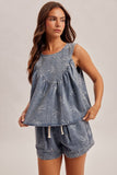 Woman wearing a denim dress and shorts set on a plain background