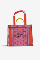 Red and pink tote bag with floral pattern and text on a white background