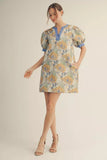 Woman wearing a floral dress with puff sleeves on a plain background