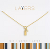 Gold necklace with a rectangular pendant on a white background, featuring the 'Layers' brand.