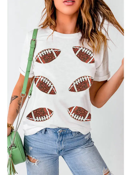 Woman wearing a white t-shirt with football designs, paired with blue jeans and a green handbag.