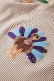 Embroidered patch of a fish on a textured beige fabric background
