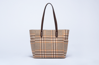 Plaid tote bag with brown handle on a light gray background