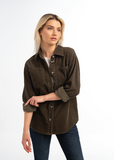 Woman wearing a brown button-up shirt and jeans on a white background