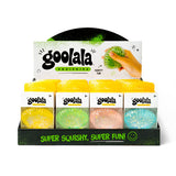 A retail display box of Goolala Squishies, showing four colorful squishy balls in yellow, green, pink, and blue, with a hand holding a green squishy behind the top card.