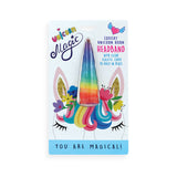A packaged unicorn horn headband on a white backing card. The horn is rainbow-colored with blue, purple, pink, orange, and yellow gradients.