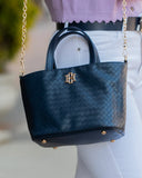 Blue handbag with gold accents on a mannequin against a blurred background