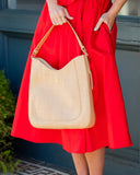 lady in red dress holding hobo natural purse
